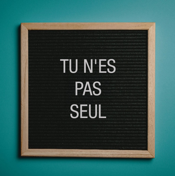 Un tableau d'affichage sur lequel on peut lire "Vous n'êtes pas seul".